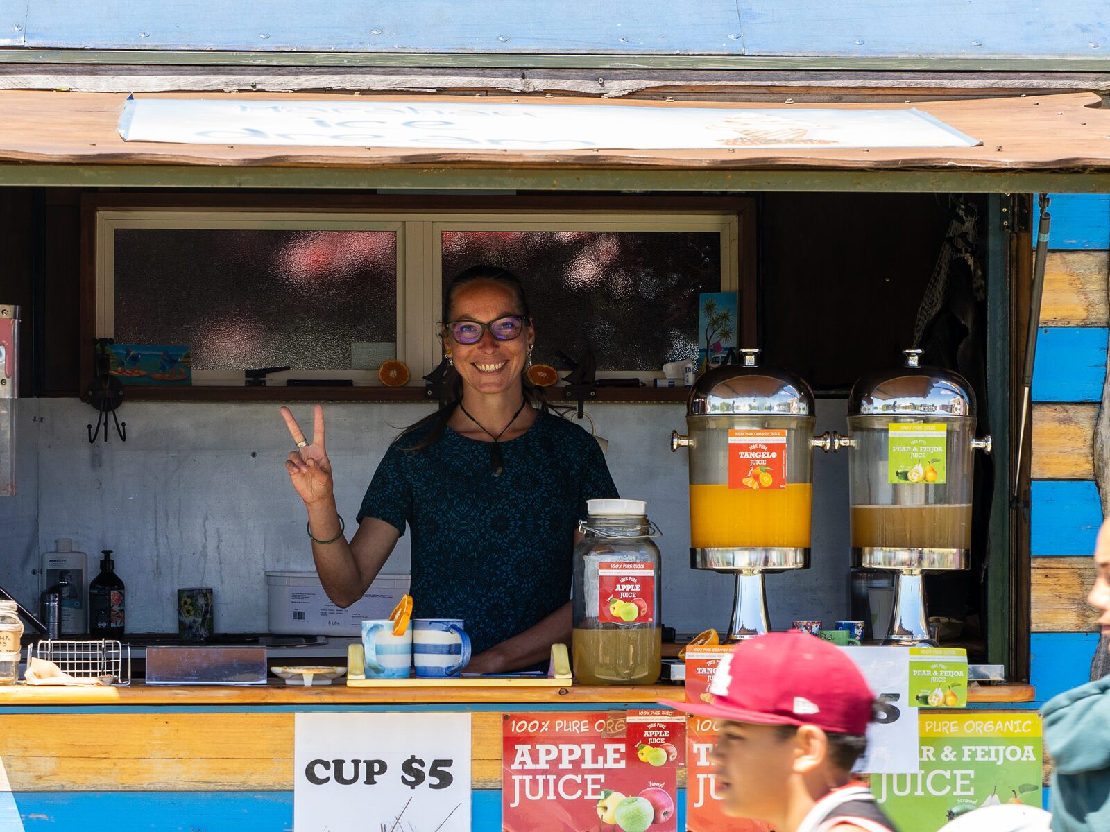 A stallholder serving fresh juice at the market and food village